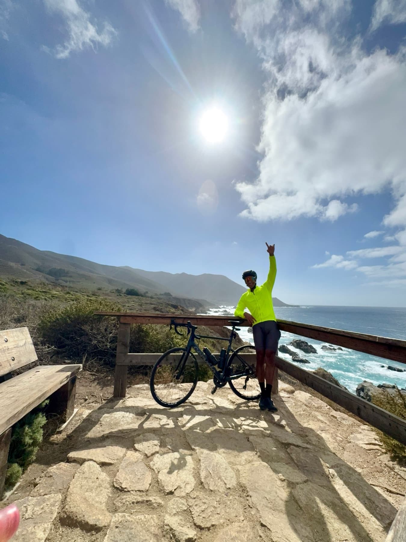 Quest with his road bike above the ocean at Big Sur