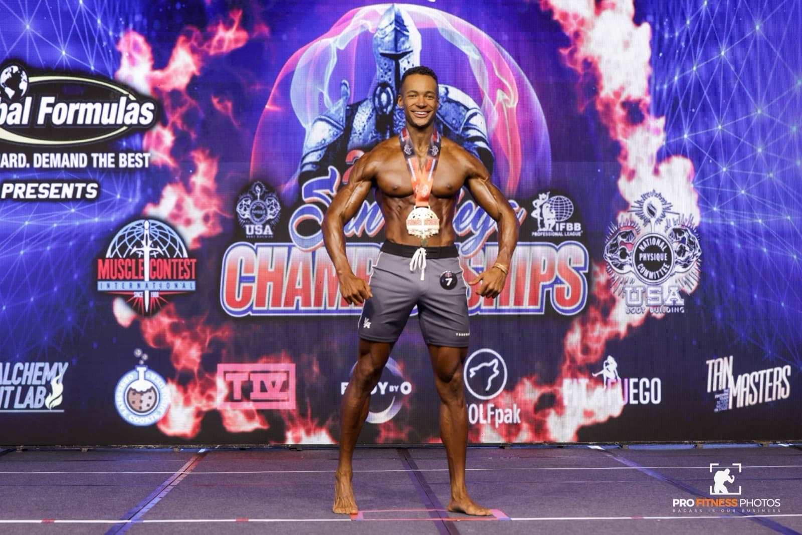 Quest on stage holding a first place medal